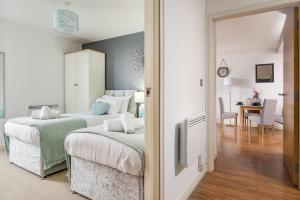 a bedroom with two beds and a dining room at Birmingham Skyline Apartment City Centre in Birmingham