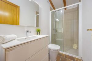 a bathroom with a toilet and a sink and a shower at Villa Plomer Serra in Playa de Muro
