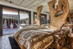 um quarto com uma cama grande com um tronco de árvore em Le petit cœur de Megève -Mont770- em Megève