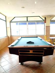 a pool table in a room with windows at Nefama Pensao in Ourique