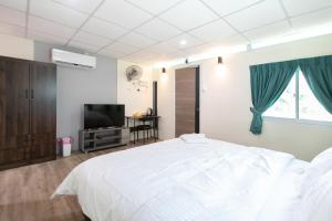 1 dormitorio con 1 cama blanca y TV de pantalla plana en Razo Mini Cabin House w/Bathroom 2pax BBQ, en Butterworth