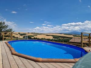 una piscina su una terrazza in legno con vista sulla campagna di Agriturismo Montepinci a Montalcino