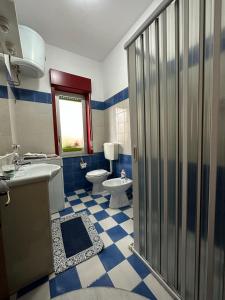 a blue and white bathroom with a toilet and a sink at Casa del Sol in Torre Forte
