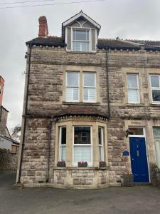 ウェルズにあるGlengarth house Room only accommodationの青いドアと窓のあるレンガ造りの家