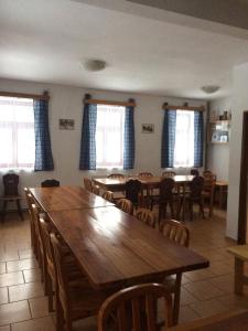 uma sala de jantar com uma grande mesa de madeira e cadeiras em Chata Čert em Josefuv Dul