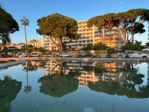 a reflection of a building in a pool of water at Apartment Cannes Rico Beach in Cannes