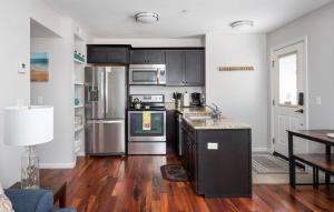 a kitchen with stainless steel appliances and wooden floors at Midtown Condo 9 Great Traverse City Location in Traverse City