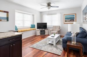 ein Wohnzimmer mit einem blauen Sofa und einem TV in der Unterkunft Midtown Condo 9 Great Traverse City Location in Traverse City