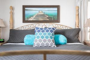 uma cama com almofadas e uma fotografia de uma estrada em Midtown Condo 9 Great Traverse City Location em Traverse City