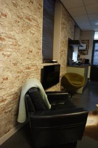 a living room with a leather couch and a chair at D'rommels Goed Slapen in Den Helder