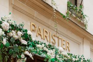 a sign on the side of a building with flowers at Hotel Parister & Spa in Paris