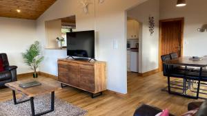 a living room with a large television and a table at Kingfisher Lodge with Hot Tub in Cupar