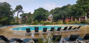 ein Haufen Stühle und ein Pool mit viel Wasser in der Unterkunft Appartement 3 pièces 4 personnes, à Moliets et Maa, proche Golf, grand balcon et piscine in Moliets-et-Maa