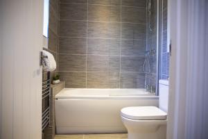 La salle de bains est pourvue d'une baignoire, de toilettes et d'un lavabo. dans l'établissement 1-Bed Apartment - FREE Parking - Town Centre, à Stratford-upon-Avon