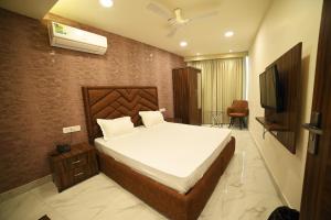 a bedroom with a bed and a television in it at OVEL HOTEL (SKY VIEW) in Ludhiana