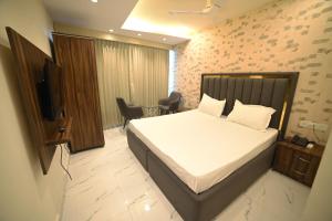 um quarto com uma cama e uma televisão num quarto em OVEL HOTEL (SKY VIEW) em Ludhiana