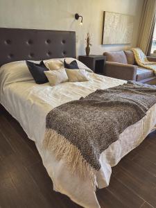 Un dormitorio con una cama grande con una manta. en Estancia Alto San Pedro en Huerta Grande