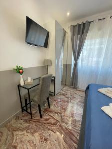 Zimmer mit einem Schreibtisch und einem TV an der Wand in der Unterkunft Henry Suite in Rom