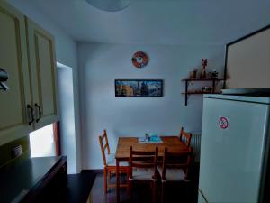 ヴィスワにあるRezydencja Wiślane Zaciszeのキッチン(テーブル、椅子、冷蔵庫付)