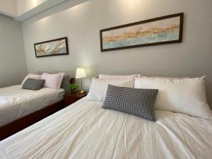 1 dormitorio con 2 camas con sábanas y almohadas blancas en Anggun Residence Walking distance 5-10mins to Sogo Chow Kit Monorail and LRT station by Juststay, en Kuala Lumpur