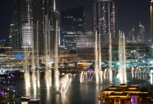 a group of water fountains in a city at night at Elite Royal Apartment - Full Burj Khalifa & Fountain view - Opal - 2 bedrooms plus 1 open bedroom without partition in Dubai