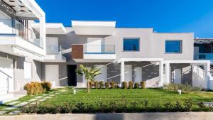 una casa con césped delante en Ofrynio Luxury Apartments & Pool, en Ofrinion