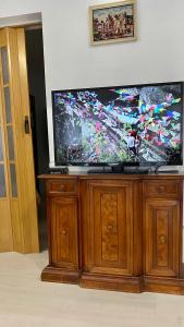 uma televisão de ecrã plano em cima de um centro de entretenimento em madeira em Alb-Rosa em Bad Herrenalb