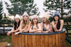 un grupo de mujeres en una bañera de hidromasaje con copas de vino en Pearl of Bukovina, en Lipovany