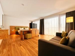 a living room with a couch and a table with a tv at Seespitz Gästehaus in Herrsching am Ammersee