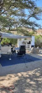 a white gazebo with a chair under it at Achab Camping Camp site in Usakos