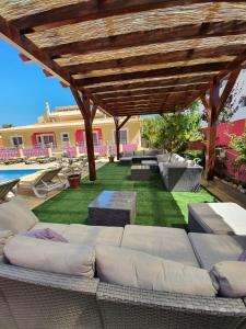 a patio with a couch under a wooden pergola at Vila Graciosa - Tranquility Oasis in Lagos