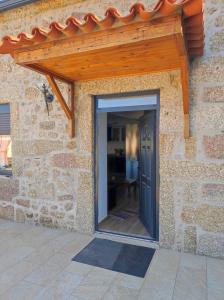 a stone house with a wooden roof and a door at Casa Cruz 