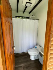 a bathroom with a toilet and a sink at Sloth Bungalows Manzanillo in Manzanillo