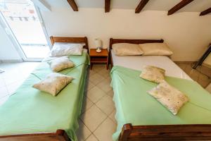 2 letti posti uno accanto all'altro in una stanza di Apartments & rooms Lucie a Posedarje (Possedaria)