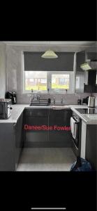 a kitchen with a sink and a window at Sunee Holidays Chalet in Hemsby