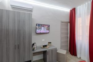Habitación con escritorio y cortina roja. en Affittacamere Alessia, en San Remo