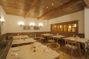 a restaurant with tables and chairs and wooden ceilings at Apart Holidays in Morschach