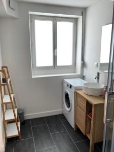 y baño con lavadora y lavamanos. en BLUE Studio cosy et calme proche du centre avec TV et Wifi, en La Rochelle