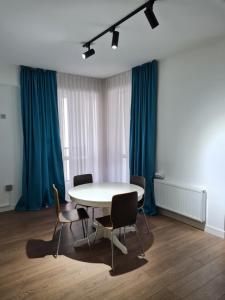una mesa y sillas en una habitación con cortinas azules en Апартаменты в новом доме, en Almaty 3 fotos más