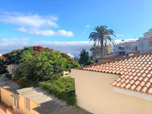 vistas a los tejados de edificios y palmeras en Precioso y amplio estudio en Puerto de La Cruz, en Puerto de la Cruz