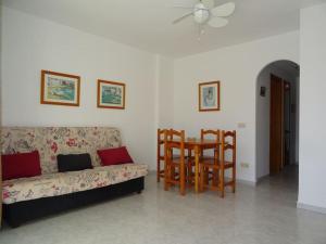 a living room with a couch and a table at AL203 céntrico, piscina y garaje AL203 in Alcossebre