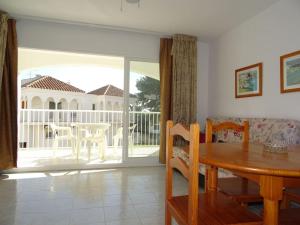 a dining room with a table and a sliding glass door at AL203 céntrico, piscina y garaje AL203 in Alcossebre