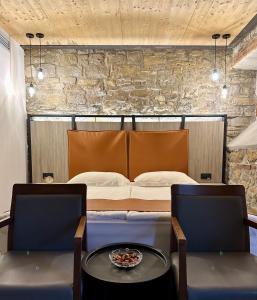 a bedroom with a bed and two chairs and a table at VENEZIANA Boutique Hotel Superior in Koper