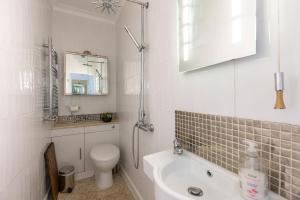 a white bathroom with a sink and a toilet at Quaint Cottage in the heart of North Yorkshire Village - Pet Friendly FREE in Stillington