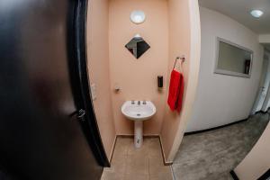 baño con lavabo blanco y toalla roja en Céntrico, Cómodo y Cálido, Dto con Hermosa Vista en Ushuaia