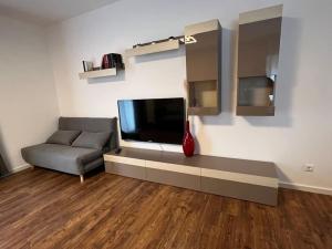a living room with a couch and a flat screen tv at Charmante Ferienwohnung Limburg in Limburg an der Lahn