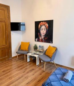 un soggiorno con due sedie e un dipinto di una donna di Topolove Rooms & Apartments a Cracovia