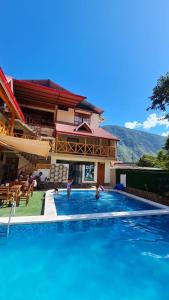 a house with a swimming pool in front of a house at Hospedaje, Cabañas y Sauna Tunki Lodge in Oxapampa