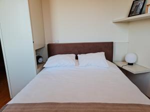 een bed met witte lakens en kussens in een kamer bij Casa na Fraga in Aldeia das Dez