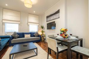 a living room with a blue couch and a table at Goodge Apartments in London